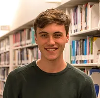 Headshot of Carson Rust in a library.